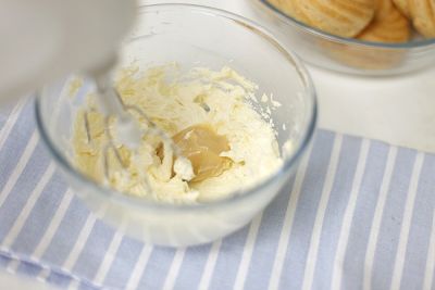 Размягченное масло взбейте с сахарной пудрой и растертым ванильным сахаром до побеления. Добавьте несколькими порциями сгущенку, тщательно взбивая на максимальной скорости. В конце добавьте коньяк.