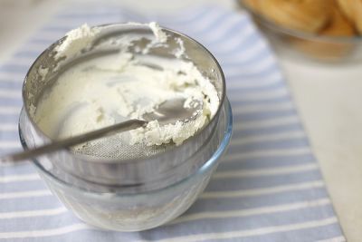 Творог протрите через сито в готовый крем. Взбейте.