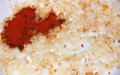 Лук мелко нарежьте. На сковороде, в жиру обжарьте лук до прозрачного состояния, убавьте огонь или снимите вовсе сковороду с огня и добавьте паприку. Всё перемешайте, верните на малый огонь, дайте прогреться паприке и пропитаться жиром. Не давая луку жариться, доведите его до потемнения.
