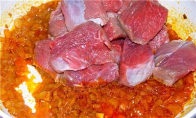 Когда лук приобретёт густую консистенцию, вкиньте мясо.
