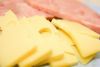 Нарежьте сыр и ветчину тонкими ломтиками, инжир - разрежьте на половинки.