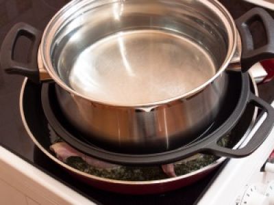 Положите на нее курицу. Накройте металлической крышкой. Сверху поставьте пресс с водой. Каждую сторону поджарьте в течение 20 минут.