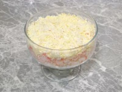 Яйца натрите на терке. Смешайте с майонезом и добавьте в креманку.