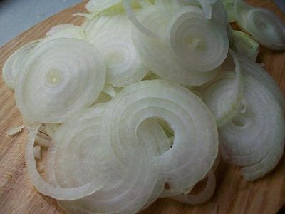 Нарезаем лук репчатый полукольцами и добавляем к болгарскому перцу.