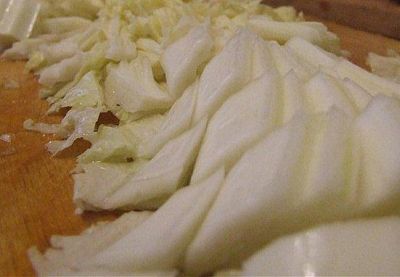 Очищенную капусту крупно нашинковать.
Тушеное мясо посолить, поперчить.Выложить капусту, готовить ее до размягчения на программе "Тушение" в течение 30 минут, затем все перемешать.