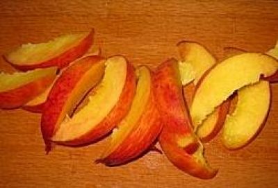 Нарежьте персики на восемь долек каждый и  и уложите на сковороду. Дайте им немного обжариться на среднем огне, переверните и влейте сок половины лимона.