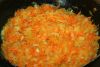 Разогреть сковороду, налить растительное масло. В горячее масло выложить лук и морковь. Тушить на среднем огне, помешивая, 2-3 минуты.