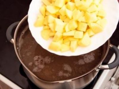 Нарезать кубиками соленые огурцы. В кипящую воду добавить картофель. Варить около 15 минут.