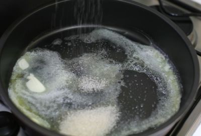 Всыпьте 100 граммов сахара и, не мешая, дождитесь, пока смесь не начнет коричневеть.