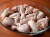 Курицу разрезаем на порционные куски и кладем в огнеупорную форму. Можно использовать ассорти из куриных голеней, бедер и крыльев. 