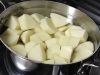 Три четверти очищенного картофеля отварите и прокрутите на мясорубке или натрите на тёрке.