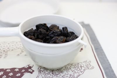 Тесто - слоеное рубленое. Его приготовление подробно описывалось в других рецептах. Порубите муку с холодным маслом в крошку, замесите тесто с 6-ю ложками воды, раскатайте, выложите в форму и оставьте в холодильнике на полчаса. Тем временем чернослив сполосните, залейте крепким чаем, оставьте, чтобы он размягчился, если плотноват. Если чернослив очень мягкий, его можно не замачивать.