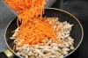 Морковь помыть, почистить и натереть на терке, желательно специальной – для корейской морковки. Лук очистить и нарезать тонкими полукольцами.
Через 2 минуты после приправ и соли добавить в сковороду куриное филе, морковь, лук и тщательно перемешать.

