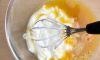Яйца разбейте в миску, добавьте щепотку соли и сметану, хорошо перемешайте венчиком или миксером.

