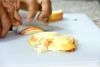 Яблоки (смешанные с лимонным соком половинки лимона) порежьте мелкими кубиками, аккуратно вмешайте в тесто.
Разогрейте духовку до 190-200 градусов.
