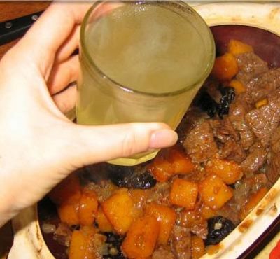 В глиняный горшок положить мясо, картофель, лук, коренья, посолить, поперчить, добавить лавровый лист, влить немного бульона.