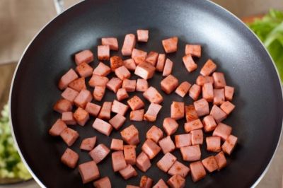 Колбасу нарежьте кубиками и обжарьте на растительном масле.