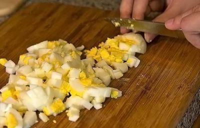Яйца сварить, очистить и мелко нарезать.