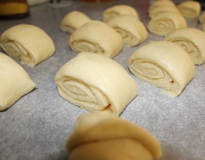 Сворачиваем в рулет, начиная с широкой стороны. И нарезаем на кусочки шириной в два пальца.
Теперь каждый кусочек надрезаем не до конца и-и-и...Разворачиваем