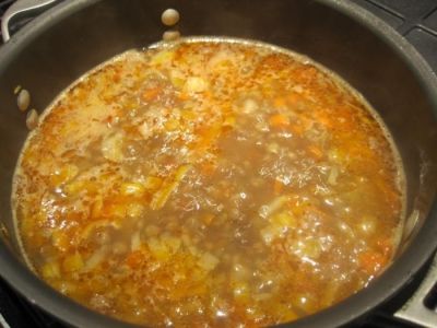 Добавьте овощи к чечевице, варите 15 минут. Положите туда же помидоры, варите 3-4 минуты. Выключите огонь, добавьте зелень.