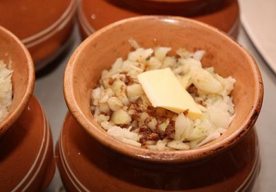 На мясо выложите мелко нарезанный лук, полейте жидкостью из сковороды и положите по кусочку масла (если мясо нежирное).