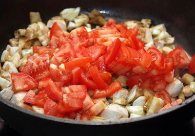 Нарежьте помидоры небольшими кусочками, выложите в сковороду.