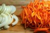 В казан или в толстостенную кастрюлю налить немного воды, добавить нарезанные полукольцами лук и соломкой морковь, обжарить их до румяного цвета. 