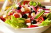 Добавьте фету, маслины и листья салата к овощам.  Для заправки: смешайте оливковое масло, уксус, соль и орегано. Полученную смесь хорошо взбейте венчиком. Полейте заправкой и перемешайте. Настоящий греческий салат готов. 
Приятного аппетита! 