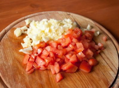 Измельчите мякоть, вынутую из кабачков, и мякоть помидора, предварительно убрав семена.